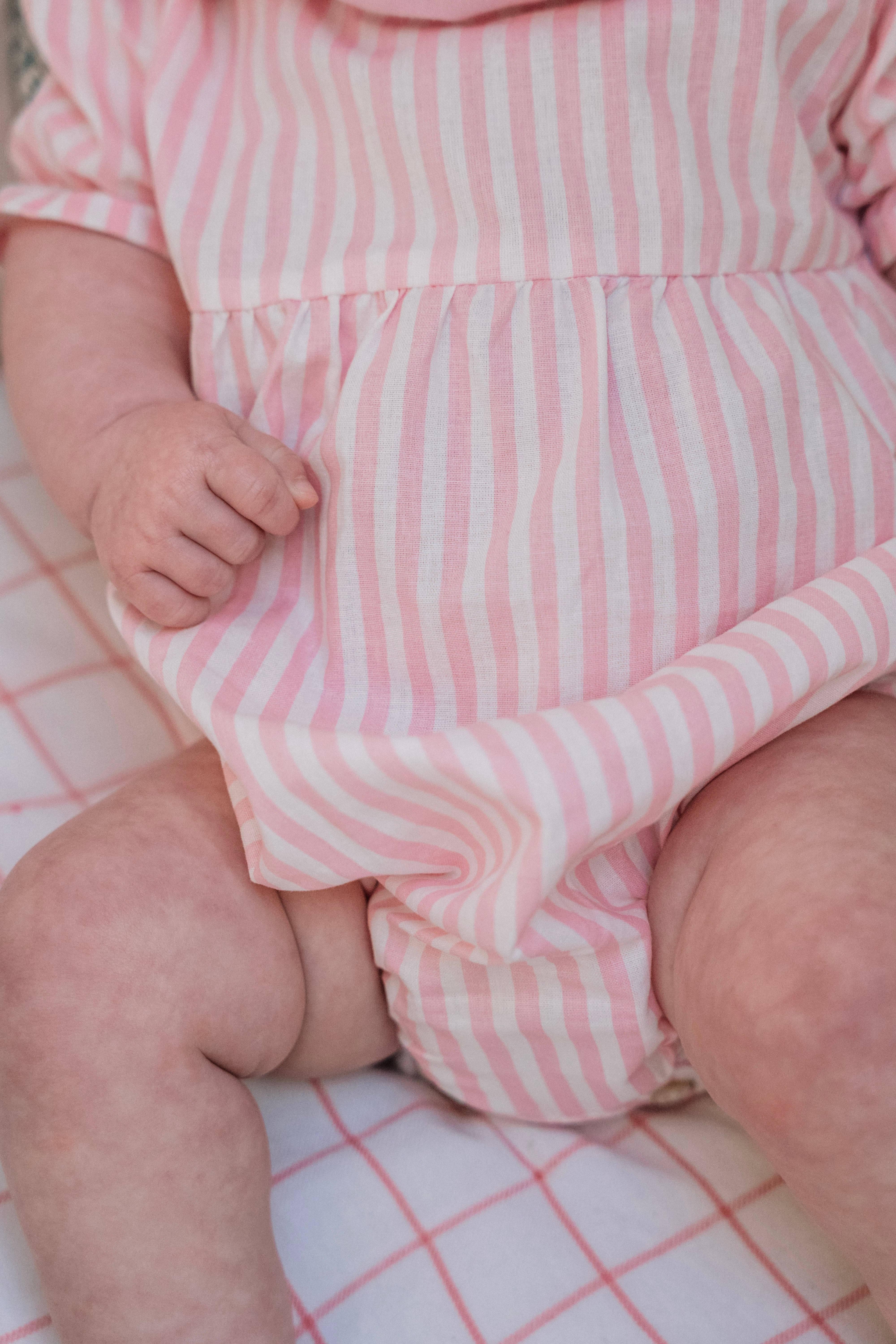 La barboteuse à double col volanté Pia rayée rose