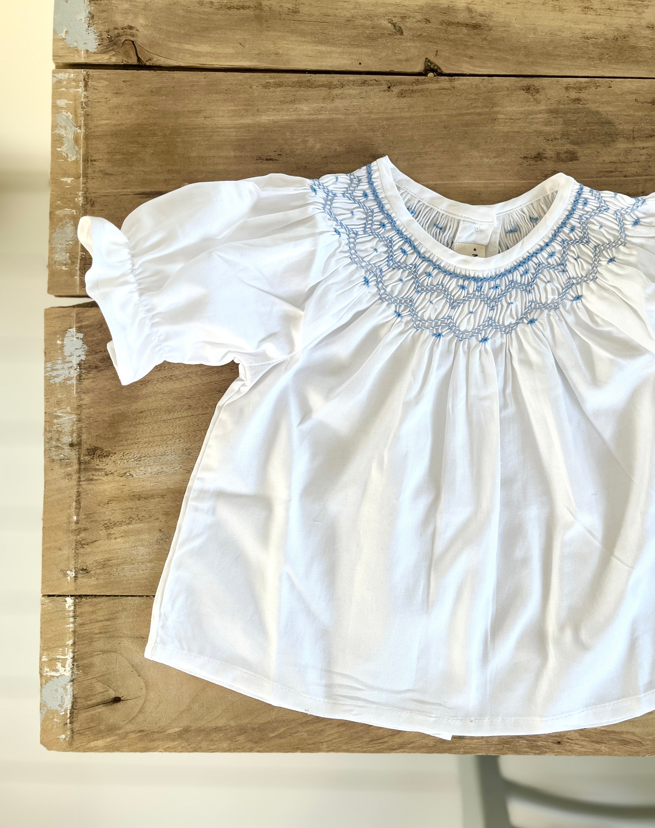 La blouse blanche à l'encolure smockée Victoire