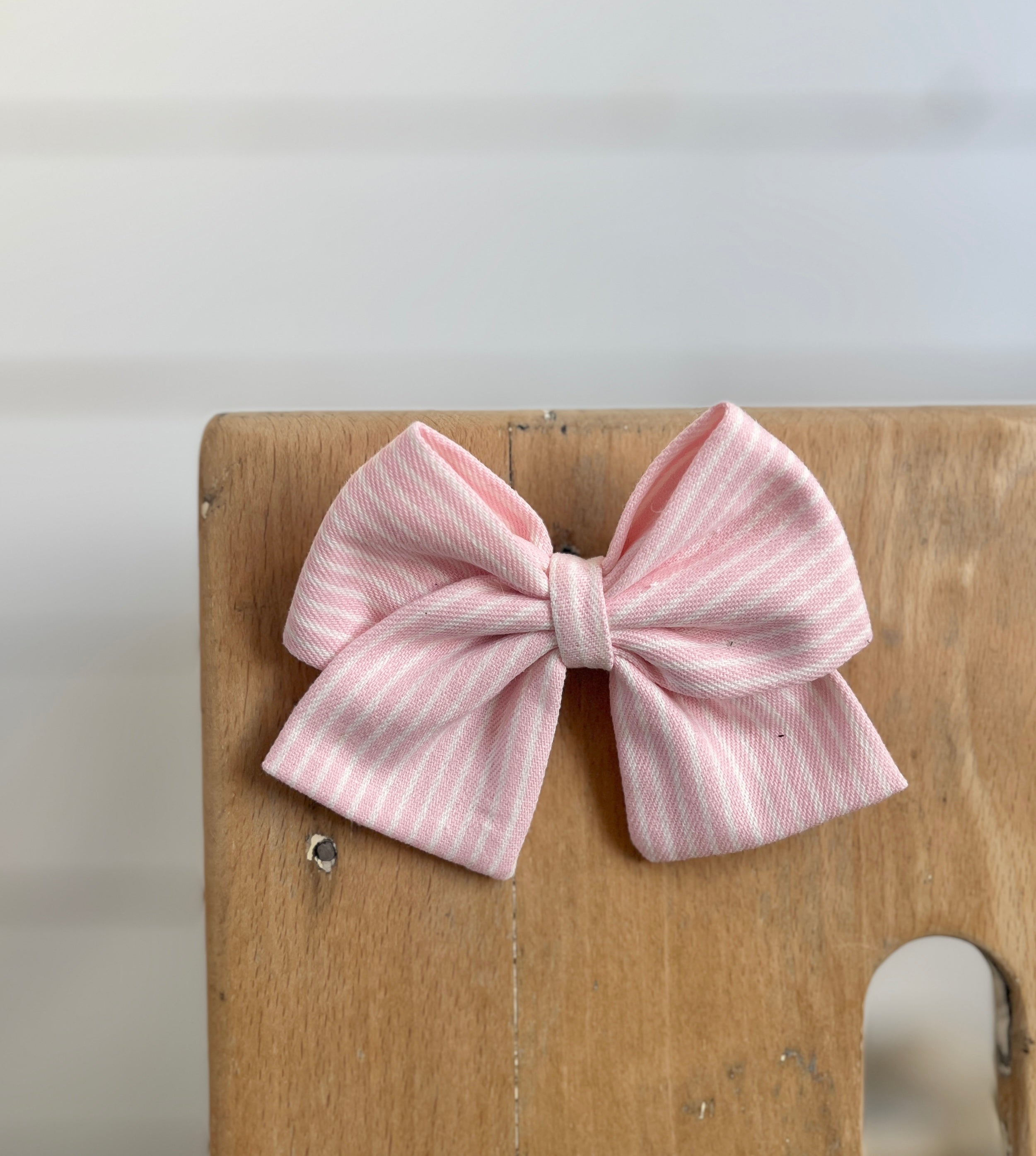 La barrette à gros noeud Brunette rayée "Oshkosh" rose pâle