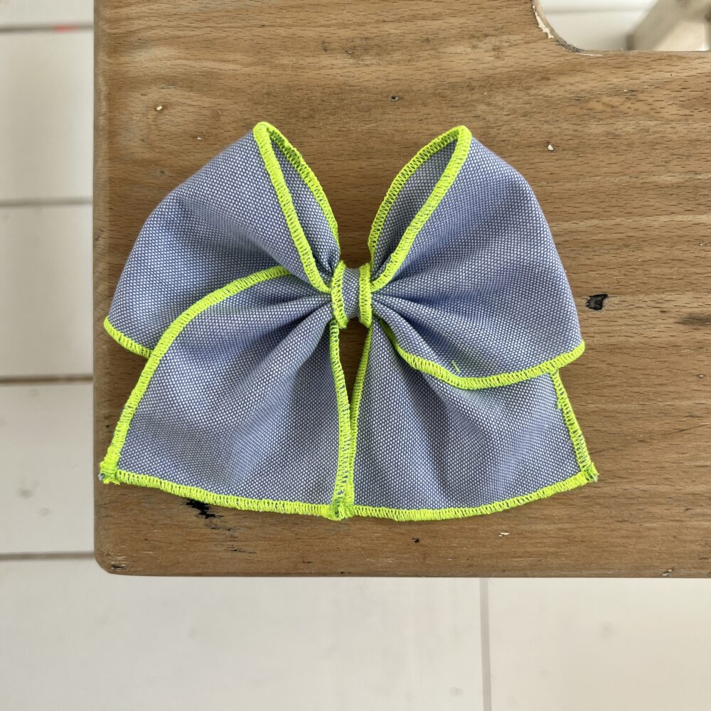 La barrette à gros nœud Brunette bicolore bleu et jaune fluo